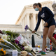 A member of the Georgetown University Women’s Rowing Team places flowers at a makeshift memorial in honor of Supreme Court Justice Ruth Bader Ginsburg in front of the U.S . Supreme Court on Saturday.